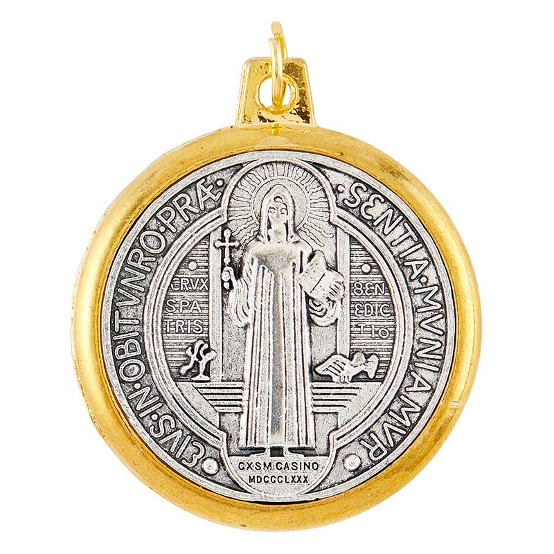 A round metal St. Benedict medal with gold tone rim and antique silver tone.