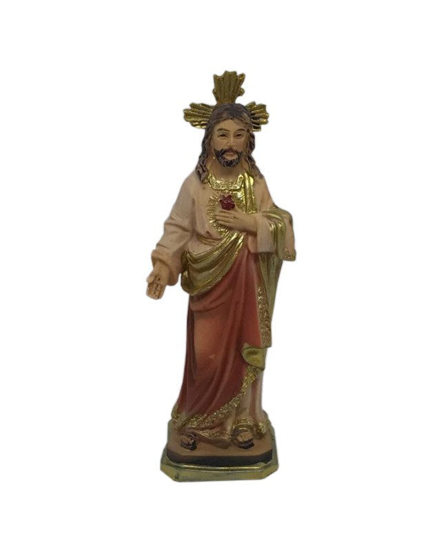 Statue of a religious figure holding a cross and heart on a white background