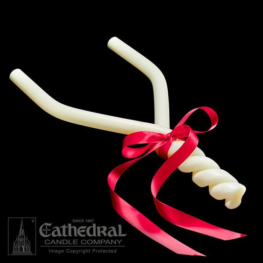 White candle with a red ribbon on a black background, featuring Cathedral Candle Company logo.