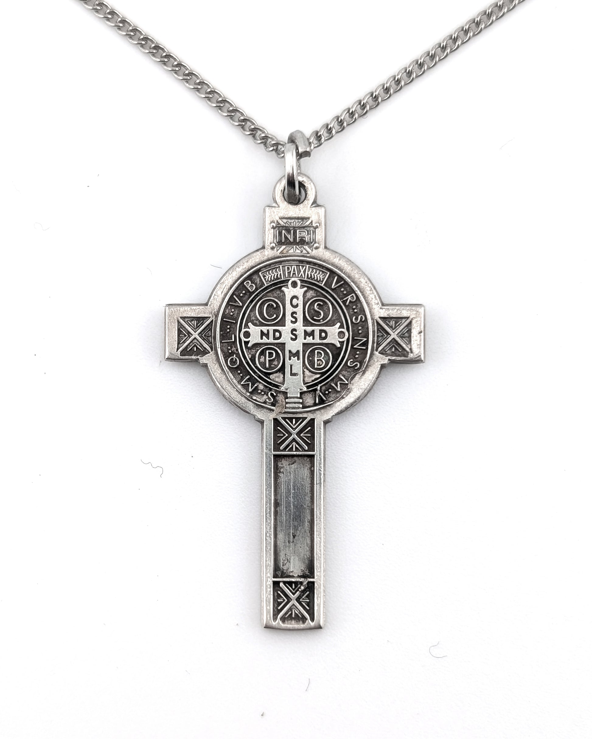 Silver cross pendant necklace on a white background
