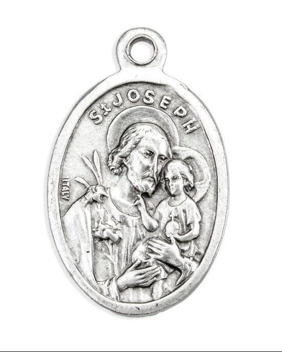 Silver medal of Saint Joseph holding a child on a white background