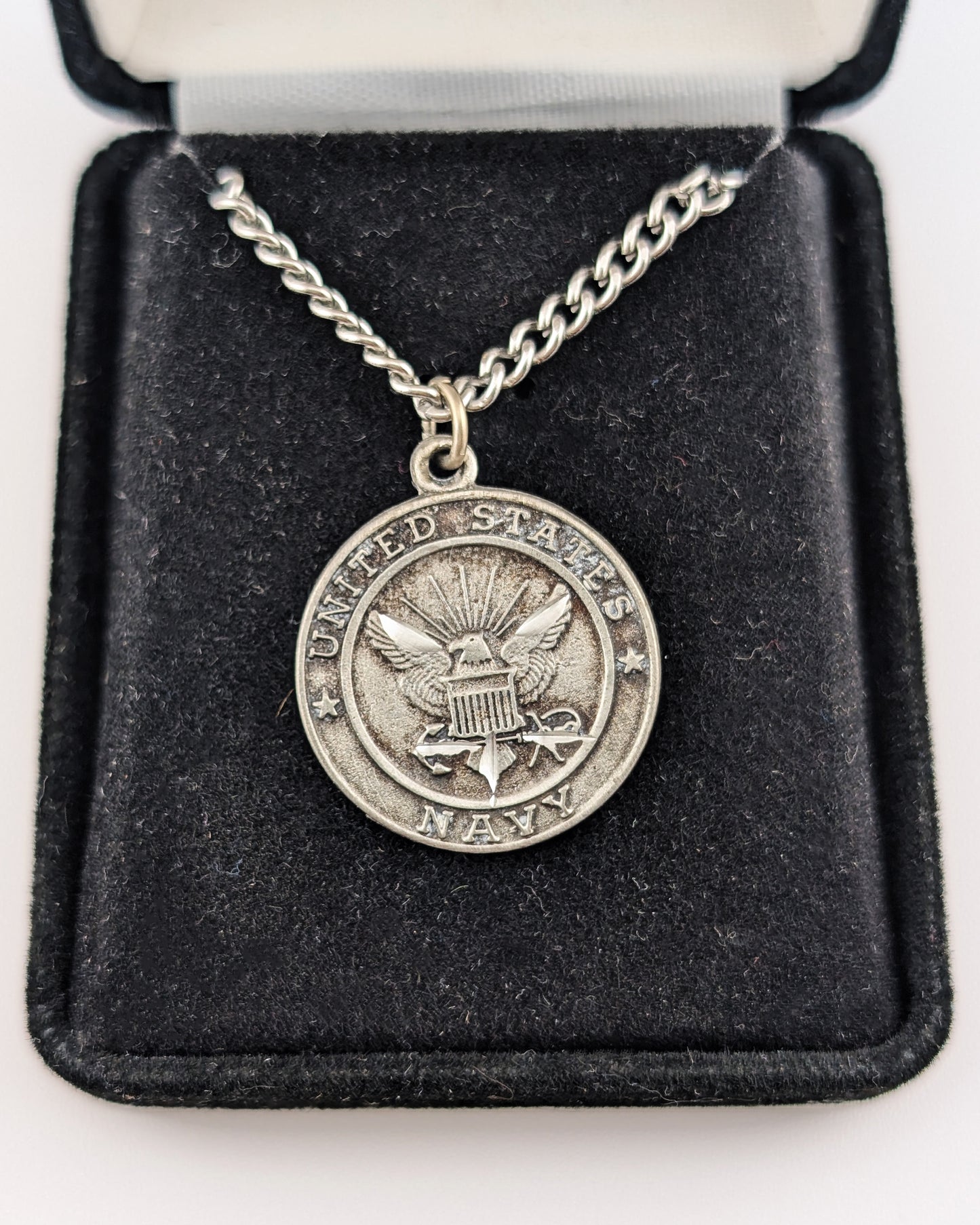Silver necklace with a U.S. Army pendant on a black velvet display box.