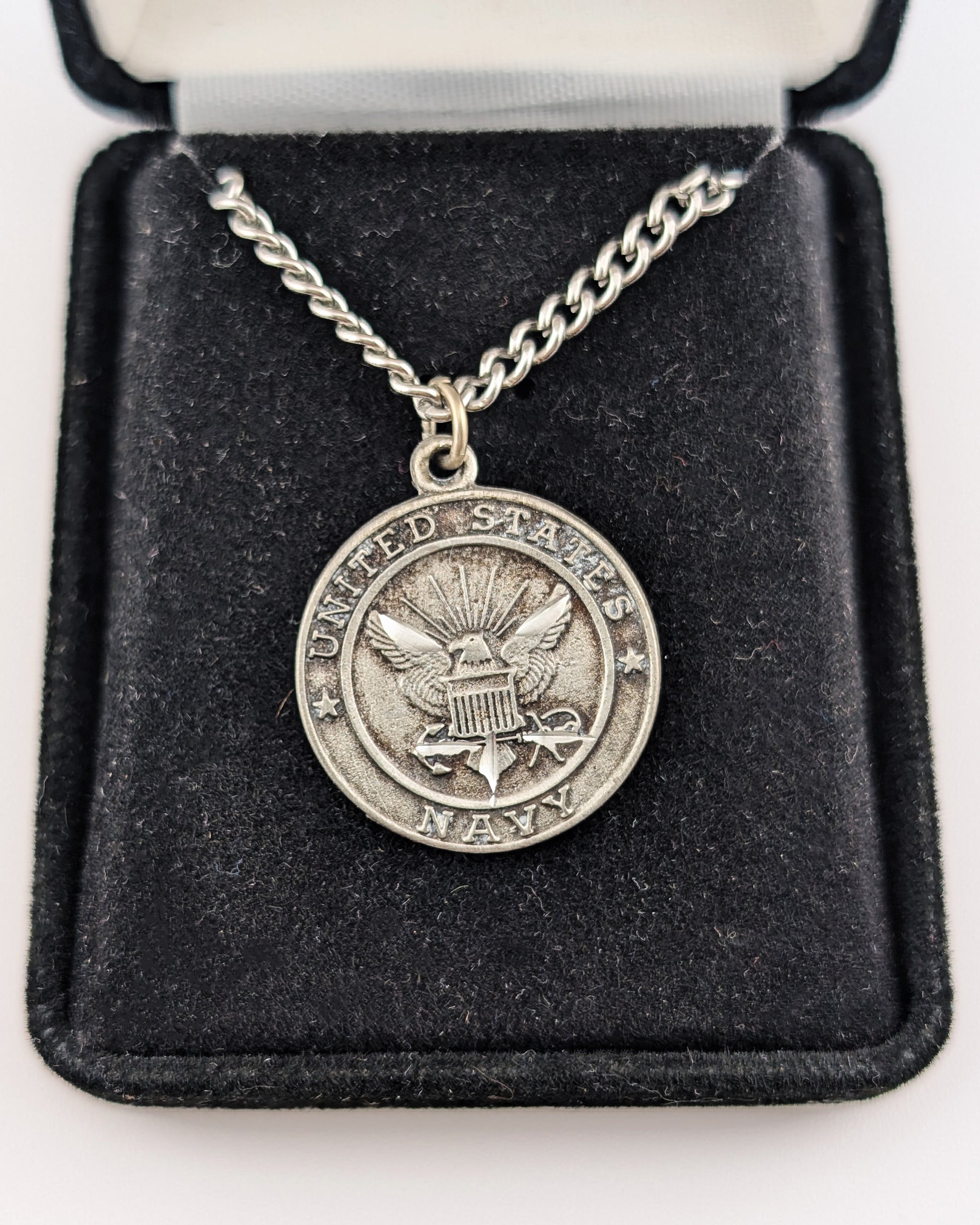 Silver necklace with a U.S. Army pendant on a black velvet display box.