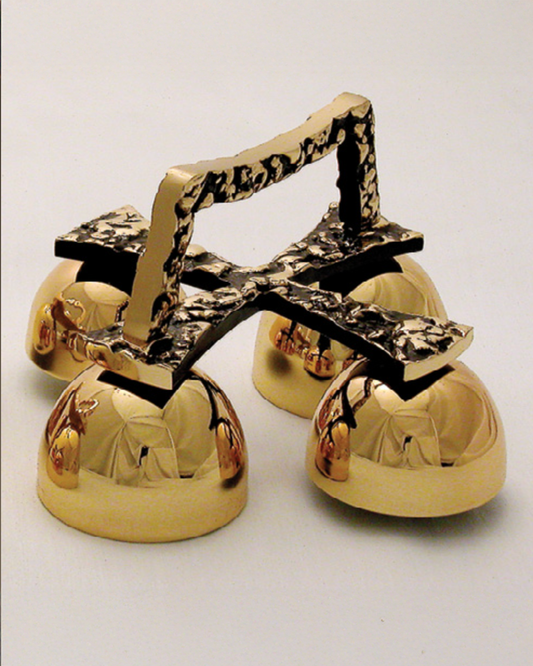 Gold cowbells with a camouflage handle on a white background