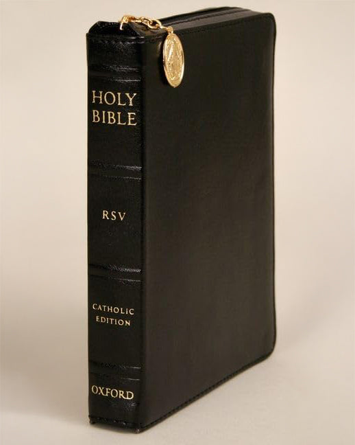 Black Bible with gold accents on a beige background