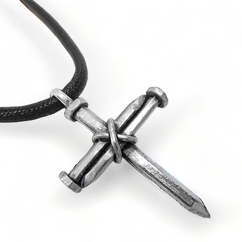 A silver three nail cross pendant on a black cord necklace.