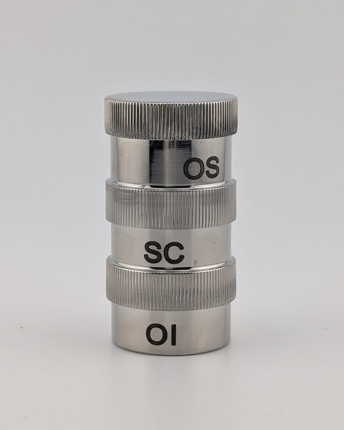 Metallic cylindrical object with 'OS', 'SC', and 'OI' markings on a white background