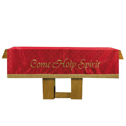 Red cloth with 'Come Holy Spirit' text on a wooden stand against a white background