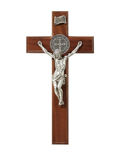 Wooden cross with silver Jesus figure and St. Benedict medal on a white background