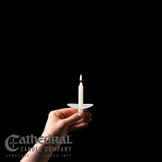 Hand holding a white candle in front of a black background with 'Cathedral Candle Company' branding.