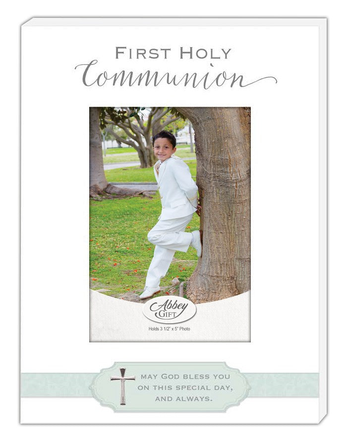 A picture frame with a photo of a child in white attire, presumably for a first communion celebration, featuring a message and accented with blue and a silver cross.