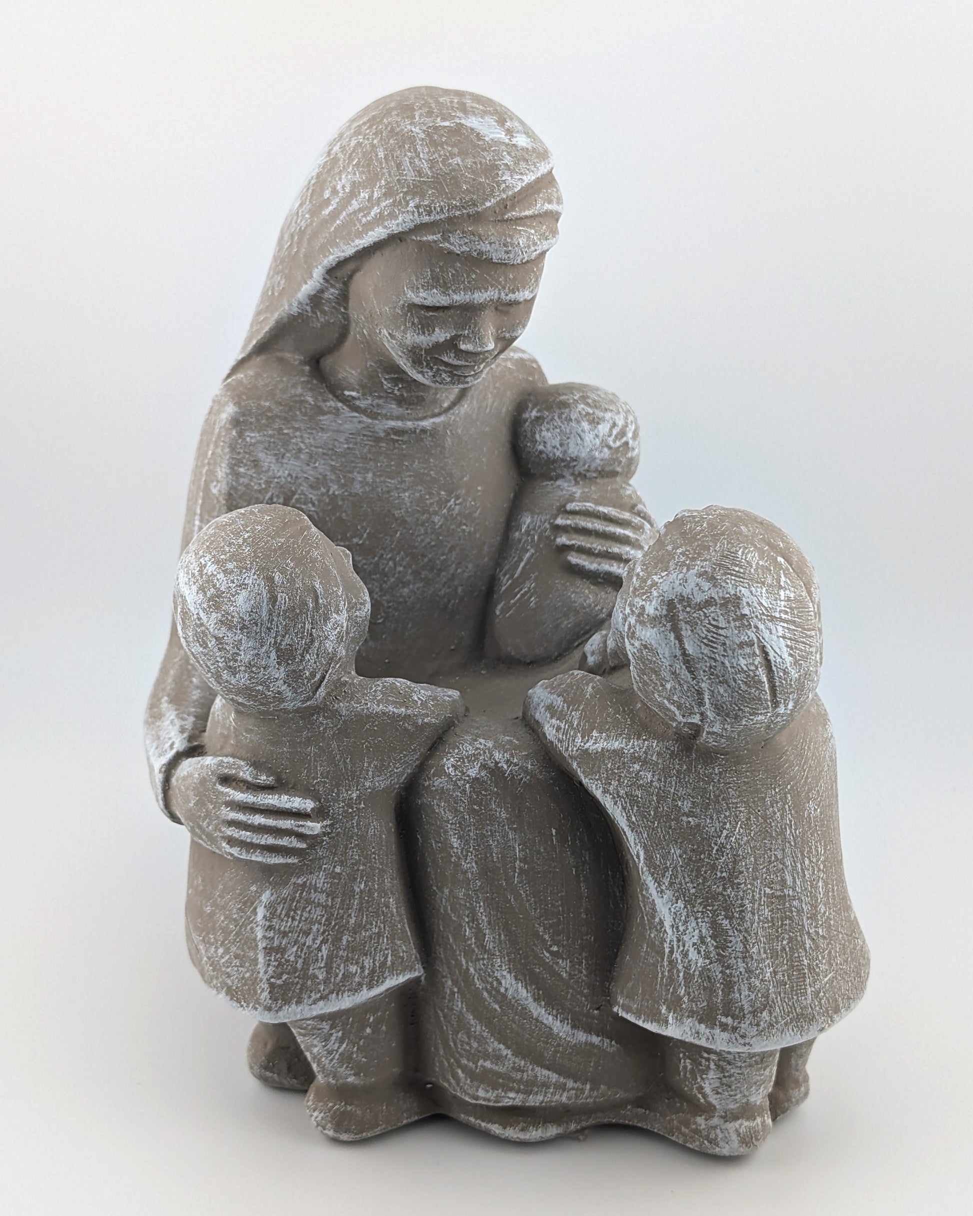 Stone sculpture of a mother holding two children on a white background