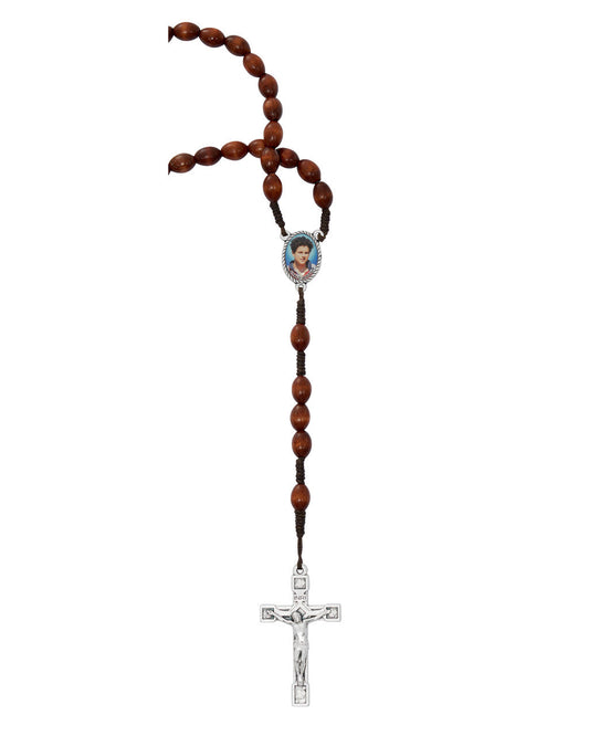 A rosary with brown wood beads and a centerpiece featuring an image of Carlo Acutis, with a silver cross at the end.