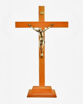 Wooden cross with a gold-colored figure of Jesus on a white background
