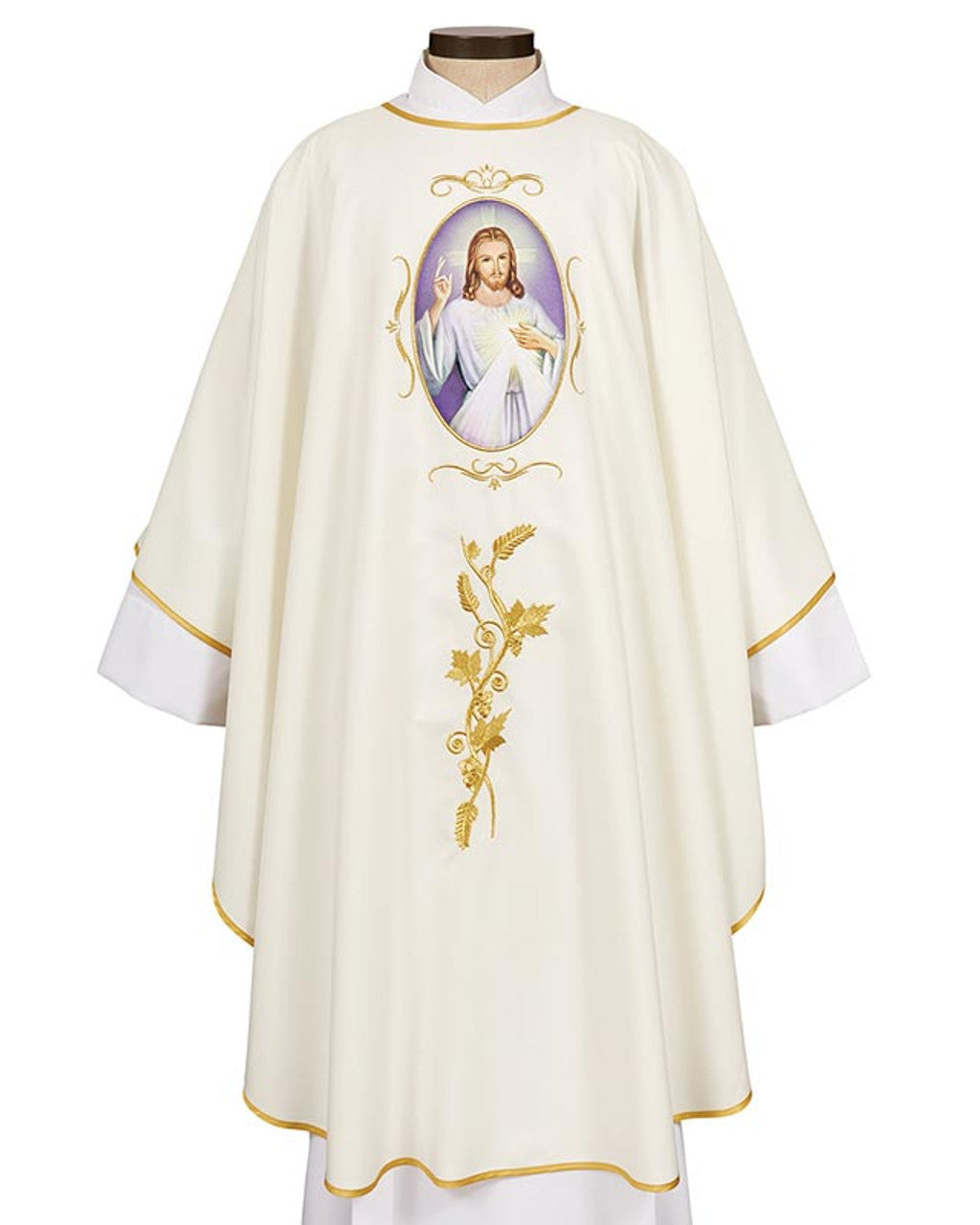 A white chasuble with gold accent embroidery and lace trim, featuring a vibrant image of Jesus Christ on the front.