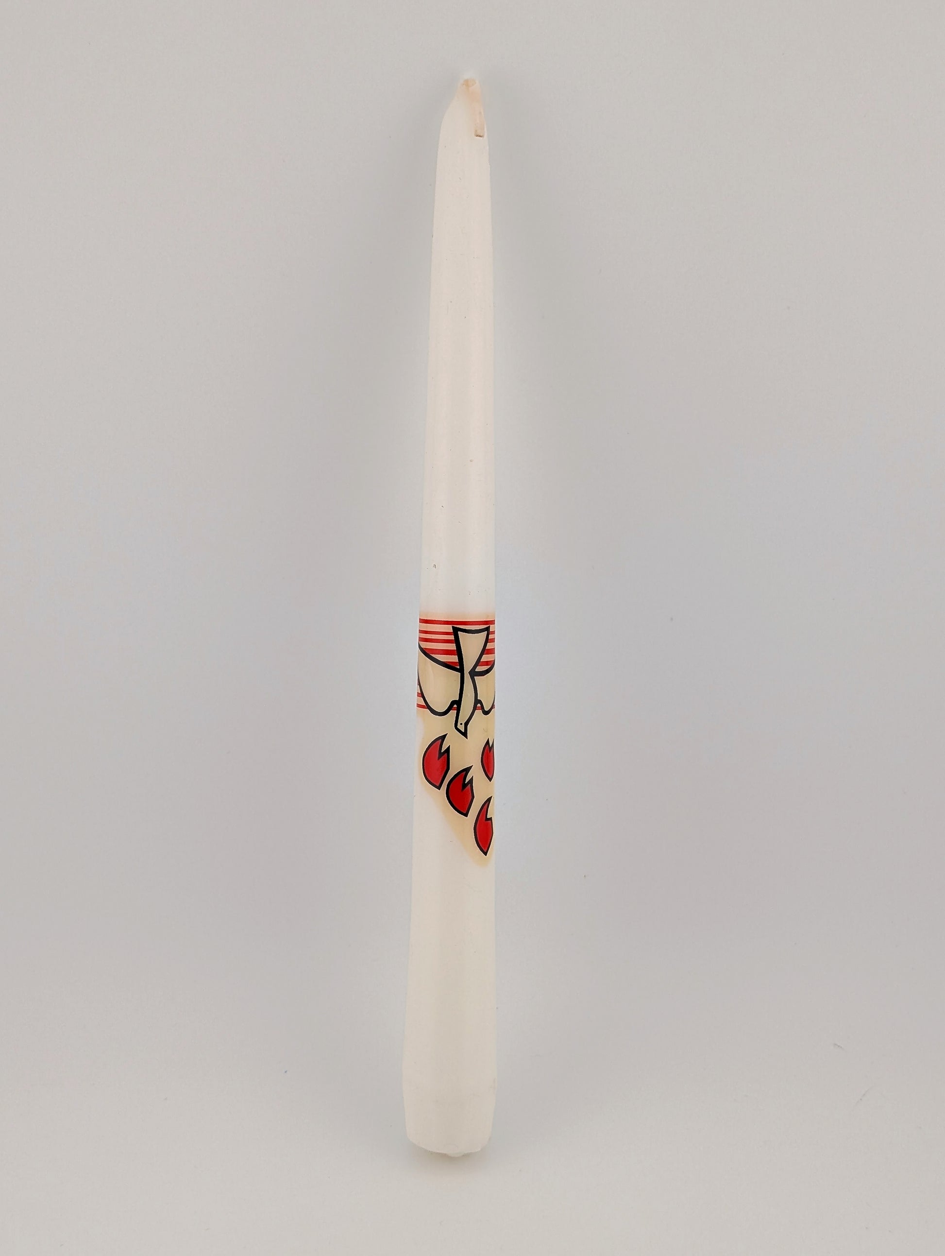Taper candle with a small decorative label on a gray background