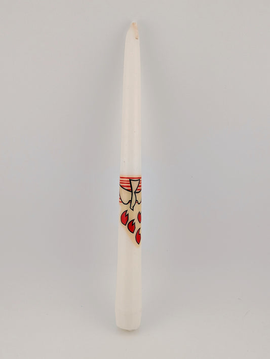 Taper candle with a small decorative label on a gray background