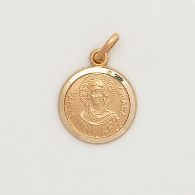 A small round 10K yellow gold medal with an embossed image of a saint, attached to a gold loop for a chain.