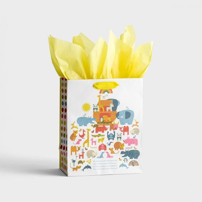 A yellow gift bag with a pattern of animals and shapes related to Noah's Ark, and a handle on top.