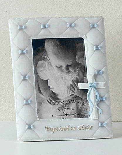 A white picture frame with blue accents designed for a 5 x 7 photo, featuring a ribbon decoration and a 'Baptized in Christ' text at the bottom.