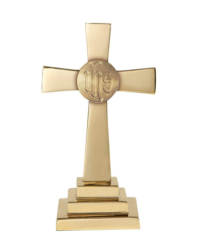 A solid brass cross with a stamped IHS design and a sturdy square base.