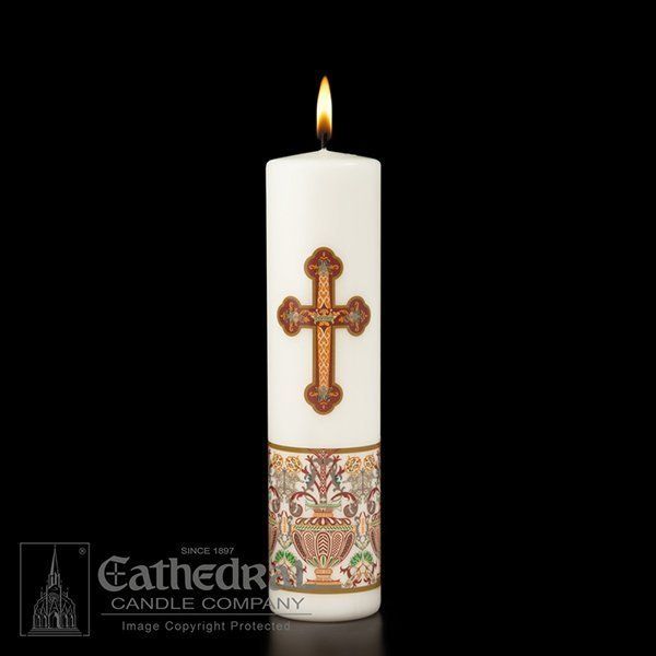 A white candle with a decorative cross and ornate details, burning with a steady flame.
