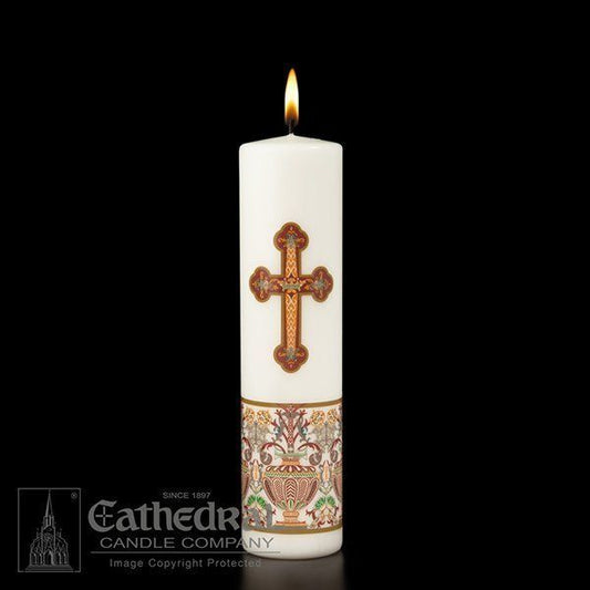 A white candle with a decorative cross and ornate details, burning with a steady flame.