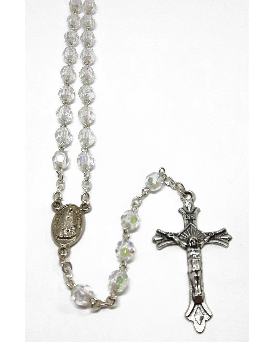 A white glass rosary with silver crucifix and a small silver chain.