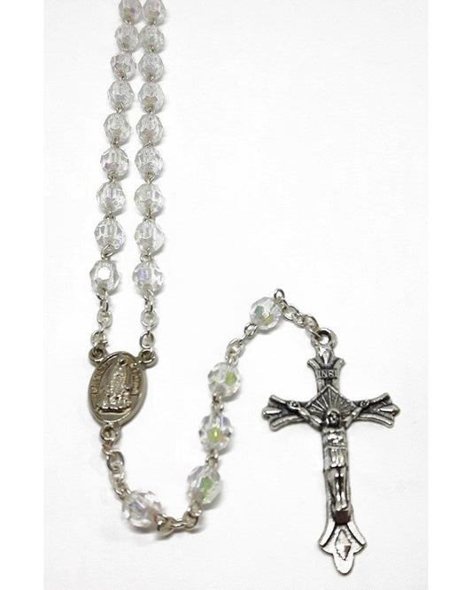 A white glass rosary with silver crucifix and a small silver chain.