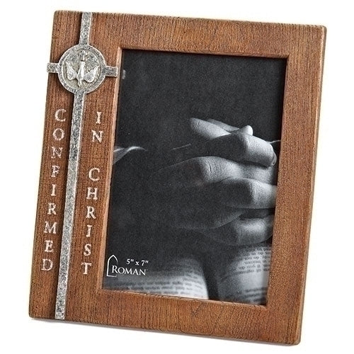 A Confirmation Frame made of resin with silver tone accents, featuring the inscription 'Confirmed in Christ' on the side, containing a photo of a person's hands holding a book.