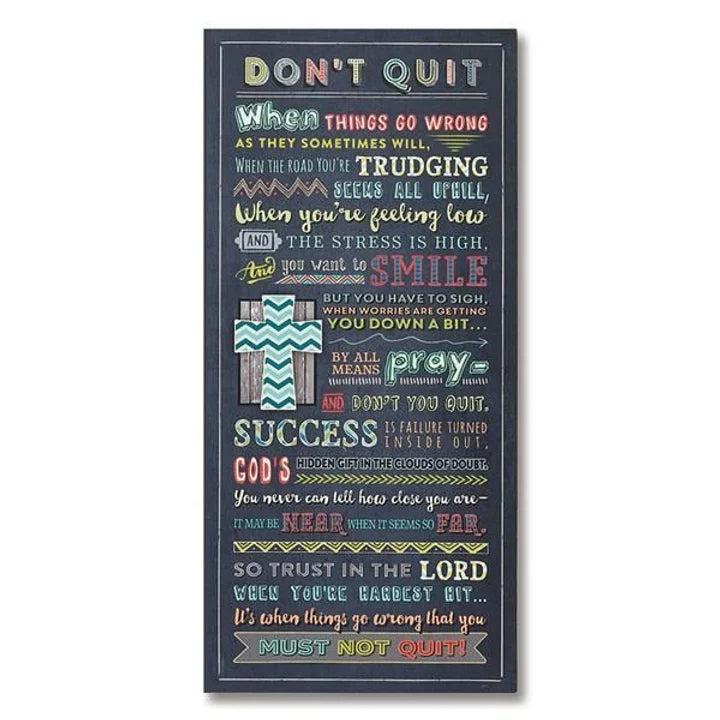 A black wall plaque with colorful text that includes various phrases related to determination and success, such as 'Don't Quit' and 'When Things Go Wrong, Don't Quit'. The plaque has a wooden appearance at the top and a white background with colorful text thereafter.