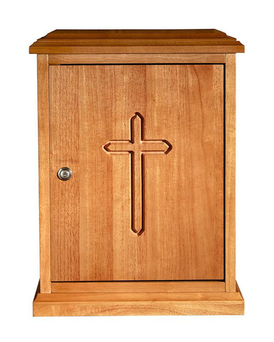 A wooden tabernacle with a plain cross design on the front door, featuring a solid oak construction with a visible lock and key assembly.