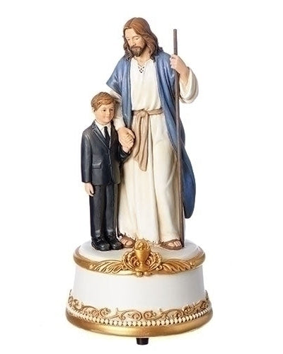A statue of Jesus and a boy dressed in a First Communion suit standing on a decorative base.
