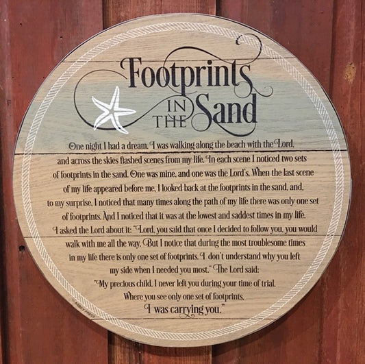 A circular wooden plaque with a silver tone metal edge, featuring an excerpt of a poem titled 'Footprints in the Sand'.