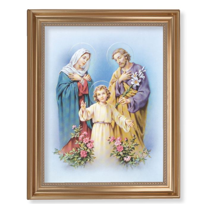 A framed picture of the Holy Family with a gold-leaf fluted frame, featuring images of Mary, Joseph, and baby Jesus with a blue background and floral motifs.