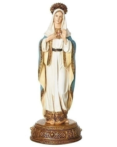 A statue of the Immaculate Heart of Mary with a golden base, wearing a white garment and a blue sash, holding a scroll and a crown, and praying with her hands together.