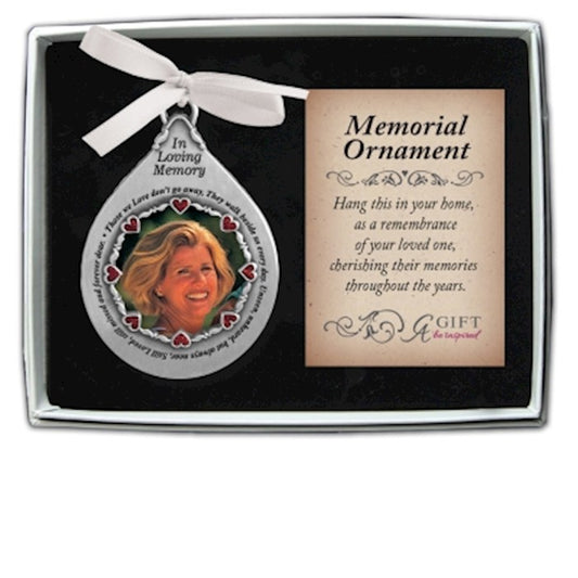 A silver teardrop frame memorial ornament with a photo of a woman, decorated with red heart crystals, a card, and a gift box.