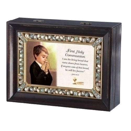 A dark wood grain music box with a jeweled frame, featuring a picture of a young boy praying and text related to First Communion.