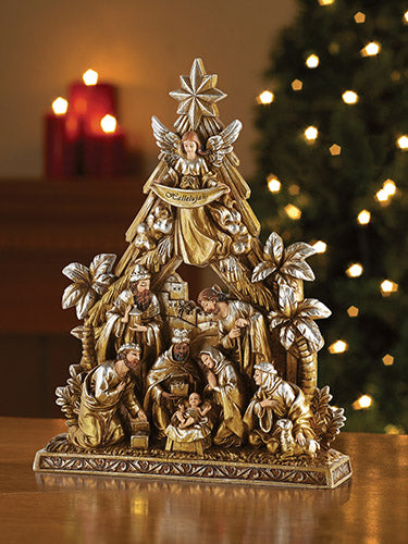 A metallic nativity figurine featuring various characters in a Christmas scene, placed against a blurred holiday-themed backdrop with lights.