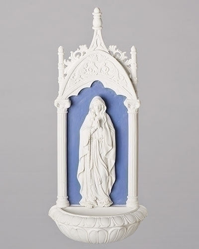 A white dolomite/resin holy water font with a blue stained glass window, designed in the Della Robbia style, featuring the Lady of Lourdes.