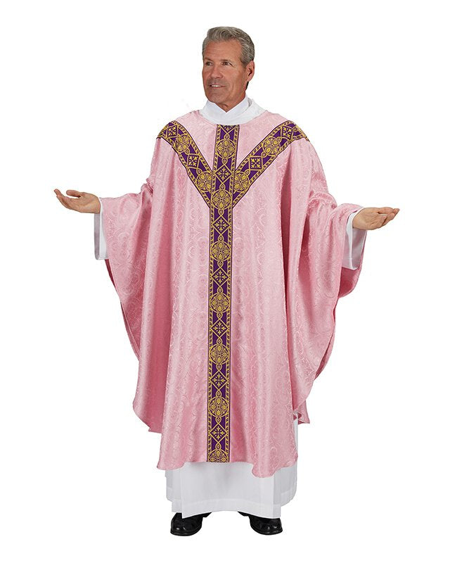 A person wearing a pink chasuble with gold metallic jacquard banding and an inner stole with matching jacquard banding. The chasuble features a Gothic style plain neck and a Y-shaped orphrey.
