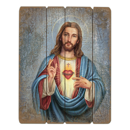 A wooden pallet sign with an image of the Sacred Heart of Jesus Christ, predominantly red and blue in color.