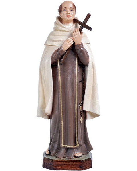 A statue of Saint John of the Cross holding a cross, wearing brown robes and a white Habit, standing on a wooden base.