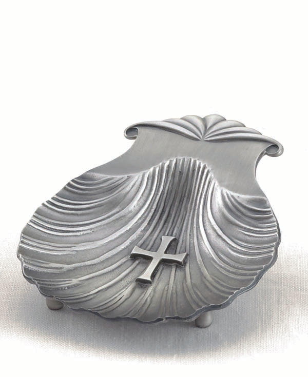 A silver-colored, scallop-shaped baptismal shell with a cross on the wing hinge.