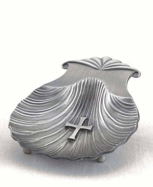 A silver-colored, scallop-shaped baptismal shell with a cross on the wing hinge.