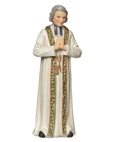 A resin statue of St. John Vianney, depicting a priest in white robes with gold and green accents, holding a book and praying.