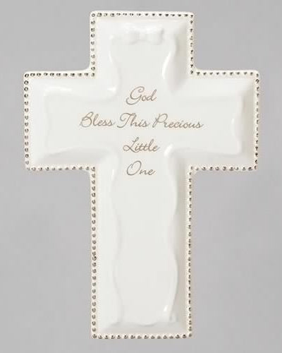 A white porcelain cross with the inscription 'GOD BLESS THIS PRECIOUS ONE' and 'LITTLE ONE' at the bottom, with bead decorations along the edges.